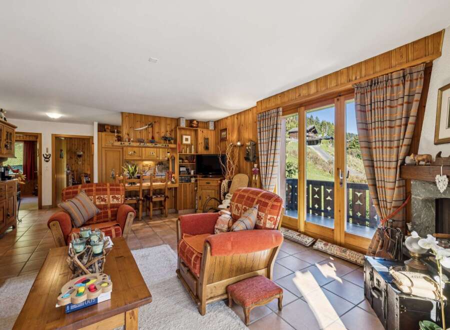 Experience cozy living in this charming mountain retreat, featuring rustic wood paneling and a warm, inviting atmosphere.