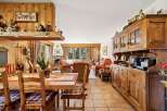 Experience rustic charm in this inviting dining and living area, featuring warm wood paneling and a cozy fireplace.
