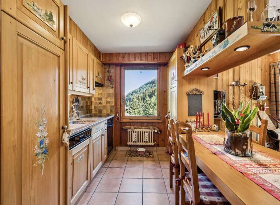 Experience rustic charm in this cozy kitchen, featuring warm wooden cabinetry adorned with hand-painted floral and pastoral motifs.