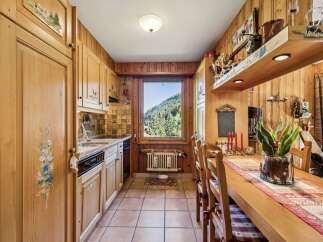 Experience rustic charm in this cozy kitchen, featuring warm wooden cabinetry adorned with hand-painted floral and pastoral motifs.