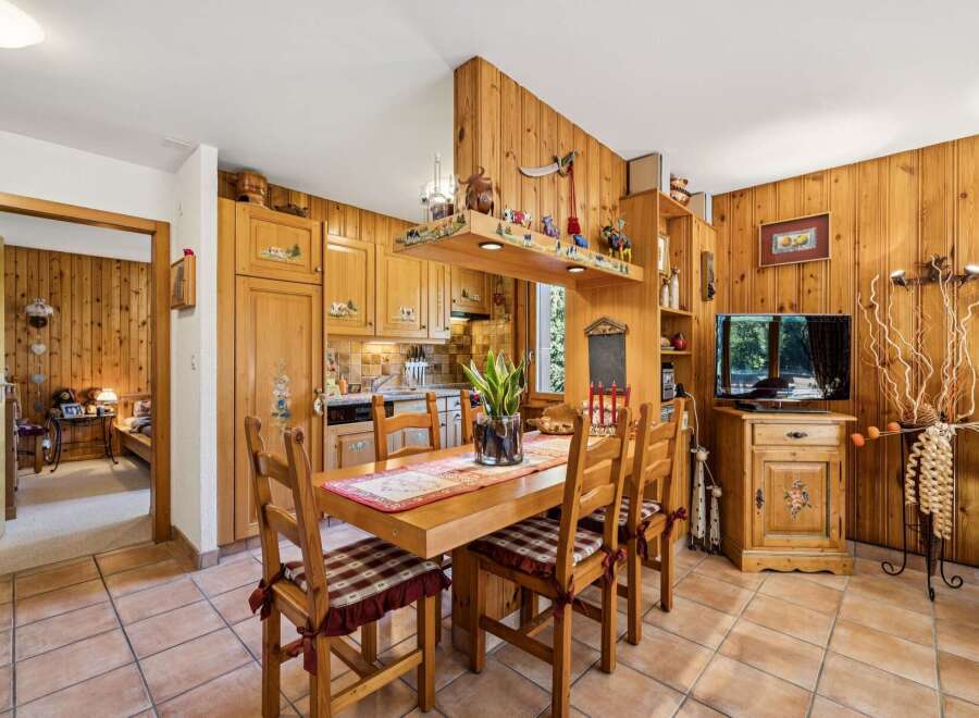 Experience rustic charm in this cozy dining area, featuring warm wooden paneling throughout and a charming wooden table set for meals.