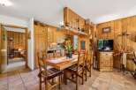 Experience rustic charm in this cozy dining area, featuring warm wooden paneling throughout and a charming wooden table set for meals.