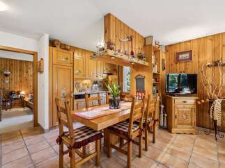 Experience rustic charm in this cozy dining area, featuring warm wooden paneling throughout and a charming wooden table set for meals.