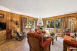 Experience cozy living in this charming mountain retreat, featuring warm wood-paneled walls and a inviting fireplace.