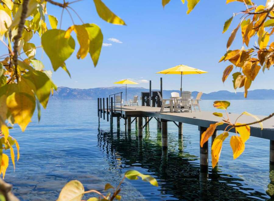 Enjoy breathtaking lake views from this stunning property featuring a private dock with seating and umbrellas.