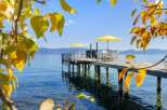 Enjoy breathtaking lake views from this stunning property featuring a private dock with seating and umbrellas.