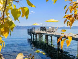Enjoy breathtaking lake views from this stunning property featuring a private dock with seating and umbrellas.