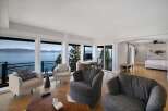 Experience breathtaking lake and mountain views from this stunning living space, featuring expansive windows that flood the room with natural light.