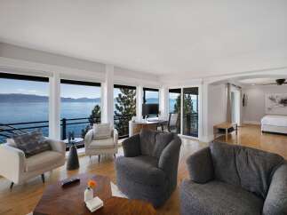 Experience breathtaking lake and mountain views from this stunning living space, featuring expansive windows that flood the room with natural light.