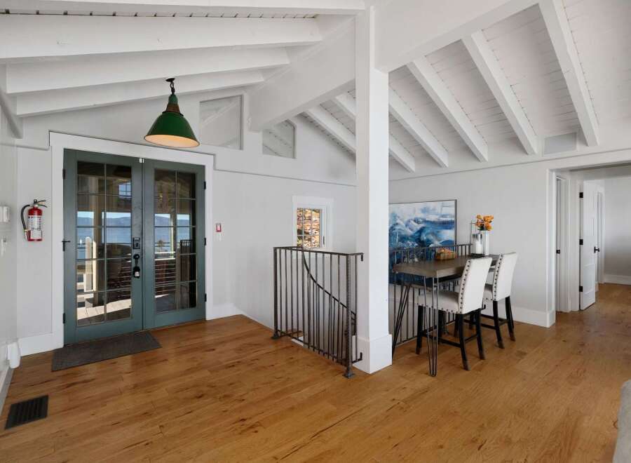 Step into this inviting coastal-inspired home featuring a spacious open-concept living area with vaulted ceilings and exposed beams.