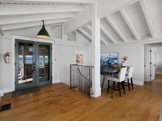 Step into this inviting coastal-inspired home featuring a spacious open-concept living area with vaulted ceilings and exposed beams.