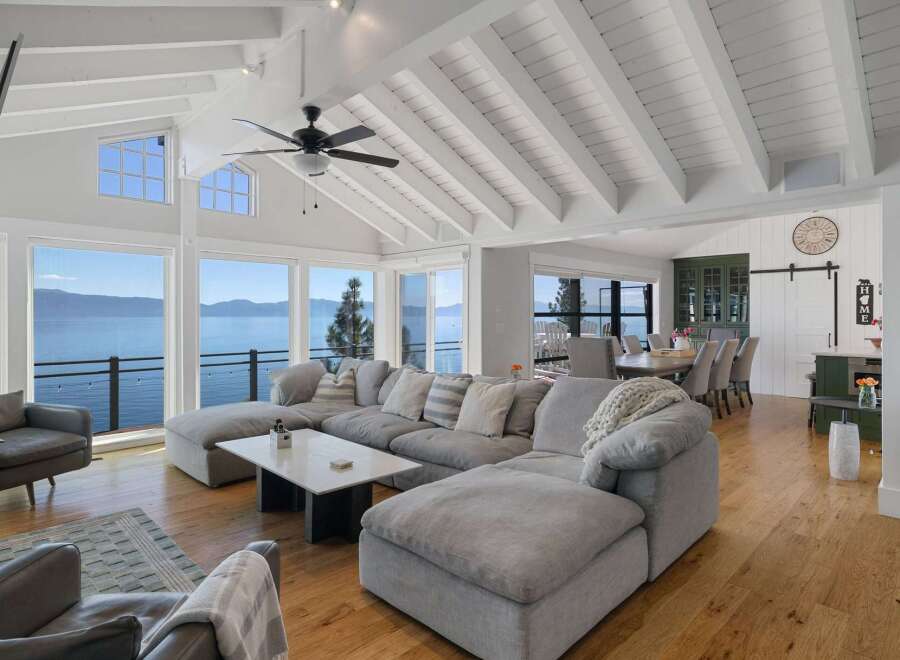 Experience breathtaking lake views from this stunning living room, featuring a spacious sectional sofa perfect for relaxation.