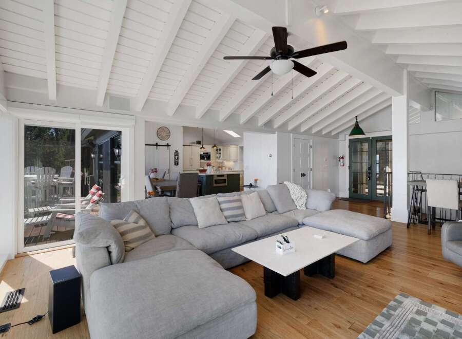 Experience coastal living in this stunning home featuring a spacious open-concept living area with vaulted ceilings and exposed beams.