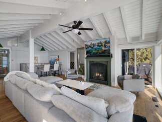 Experience coastal living in this stunning living room, featuring a cozy fireplace and a large sectional sofa perfect for relaxation.
