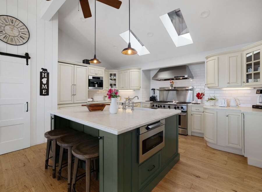 This spacious kitchen boasts a large island with seating and a built-in microwave, perfect for entertaining.