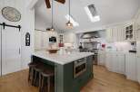 This spacious kitchen boasts a large island with seating and a built-in microwave, perfect for entertaining.