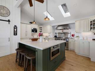 This spacious kitchen boasts a large island with seating and a built-in microwave, perfect for entertaining.