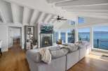 Experience breathtaking lakefront living in this stunning living room, featuring a cozy fireplace and a large sectional sofa perfect for gatherings.