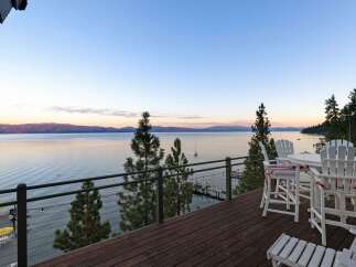 Enjoy breathtaking lake views from this stunning property's expansive deck, perfect for entertaining or quiet relaxation.