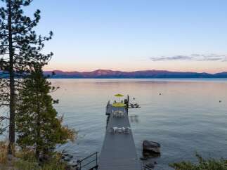 Experience serene lakefront living with this stunning property featuring a private dock perfect for morning coffee or evening relaxation.