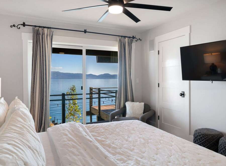 Wake up to breathtaking lake views from this serene bedroom.