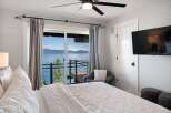 Wake up to breathtaking lake views from this serene bedroom.