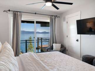 Wake up to breathtaking lake views from this serene bedroom.