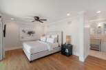 Experience luxury and comfort in this beautifully appointed bedroom, featuring a plush king-size bed with crisp white linens and a striking abstract artwork above.