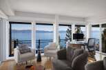 Experience breathtaking lake and mountain views from this stunning living space, featuring expansive windows that flood the room with natural light.