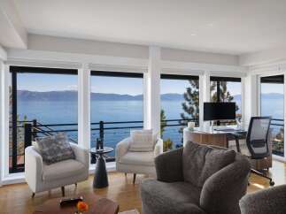 Experience breathtaking lake and mountain views from this stunning living space, featuring expansive windows that flood the room with natural light.