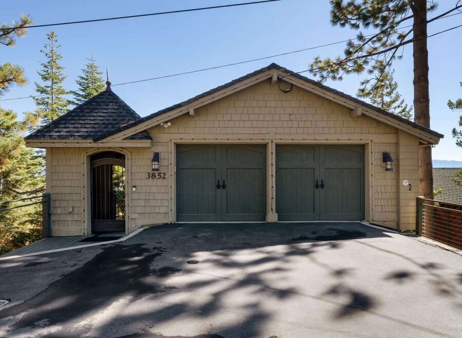 This charming property features a spacious two-car garage with classic dark green doors, perfect for protecting your vehicles.
