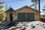 This charming property features a spacious two-car garage with classic dark green doors, perfect for protecting your vehicles.