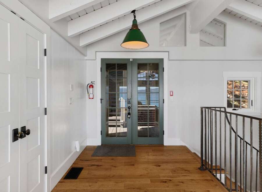 Step into this charming entryway featuring a bright and airy atmosphere, complemented by a vaulted ceiling and exposed beams.