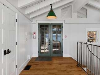 Step into this charming entryway featuring a bright and airy atmosphere, complemented by a vaulted ceiling and exposed beams.