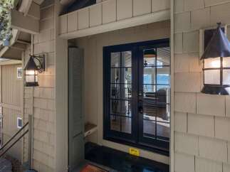 Welcome guests to your home with this charming entryway featuring rustic outdoor lighting and a covered porch.