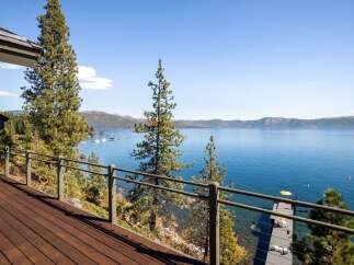 Experience breathtaking lake views from this stunning property, featuring a spacious wooden deck perfect for entertaining or relaxing.