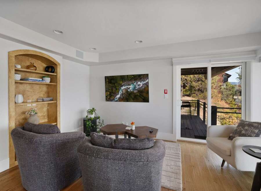 Experience breathtaking natural beauty from this living room, featuring a stunning aerial view of a river and forest displayed on a wall-mounted television.