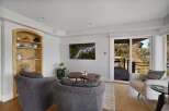Experience breathtaking natural beauty from this living room, featuring a stunning aerial view of a river and forest displayed on a wall-mounted television.