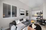 Experience comfortable living in this stylish studio apartment, featuring a plush gray sofa adorned with decorative pillows, including one that reads 'Lake House.