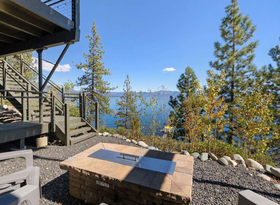 Enjoy breathtaking lake views from this stunning property, featuring a modern fire pit area perfect for evening gatherings.