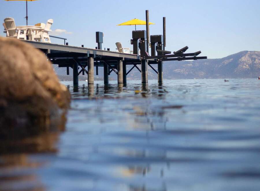 Enjoy the serene lakefront lifestyle with this stunning property featuring a private dock and ample outdoor seating.
