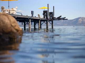 Enjoy the serene lakefront lifestyle with this stunning property featuring a private dock and ample outdoor seating.