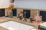 This bathroom features a sleek concrete countertop with an undermount sink, complemented by a stylish oil-rubbed bronze faucet.