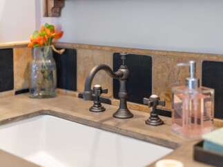 This bathroom features a sleek concrete countertop with an undermount sink, complemented by a stylish oil-rubbed bronze faucet.
