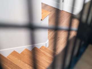 Step into this beautifully designed home featuring elegant hardwood stairs that lead to a well-lit landing.