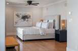 Experience modern comfort in this elegantly appointed bedroom, featuring a plush king-sized bed with crisp, striped linens and a sophisticated upholstered headboard.