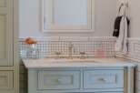 This elegant bathroom vanity features a marble countertop and a light blue cabinet with decorative knobs.