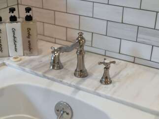Experience luxury in this bathroom, featuring a sleek marble countertop and elegant chrome fixtures.