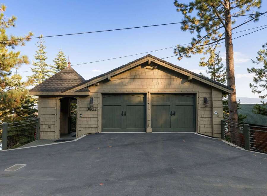 This property features a charming two-car garage with a distinctive architectural style, including shake siding and a unique turret-like entrance.