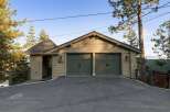 This property features a charming two-car garage with a distinctive architectural style, including shake siding and a unique turret-like entrance.
